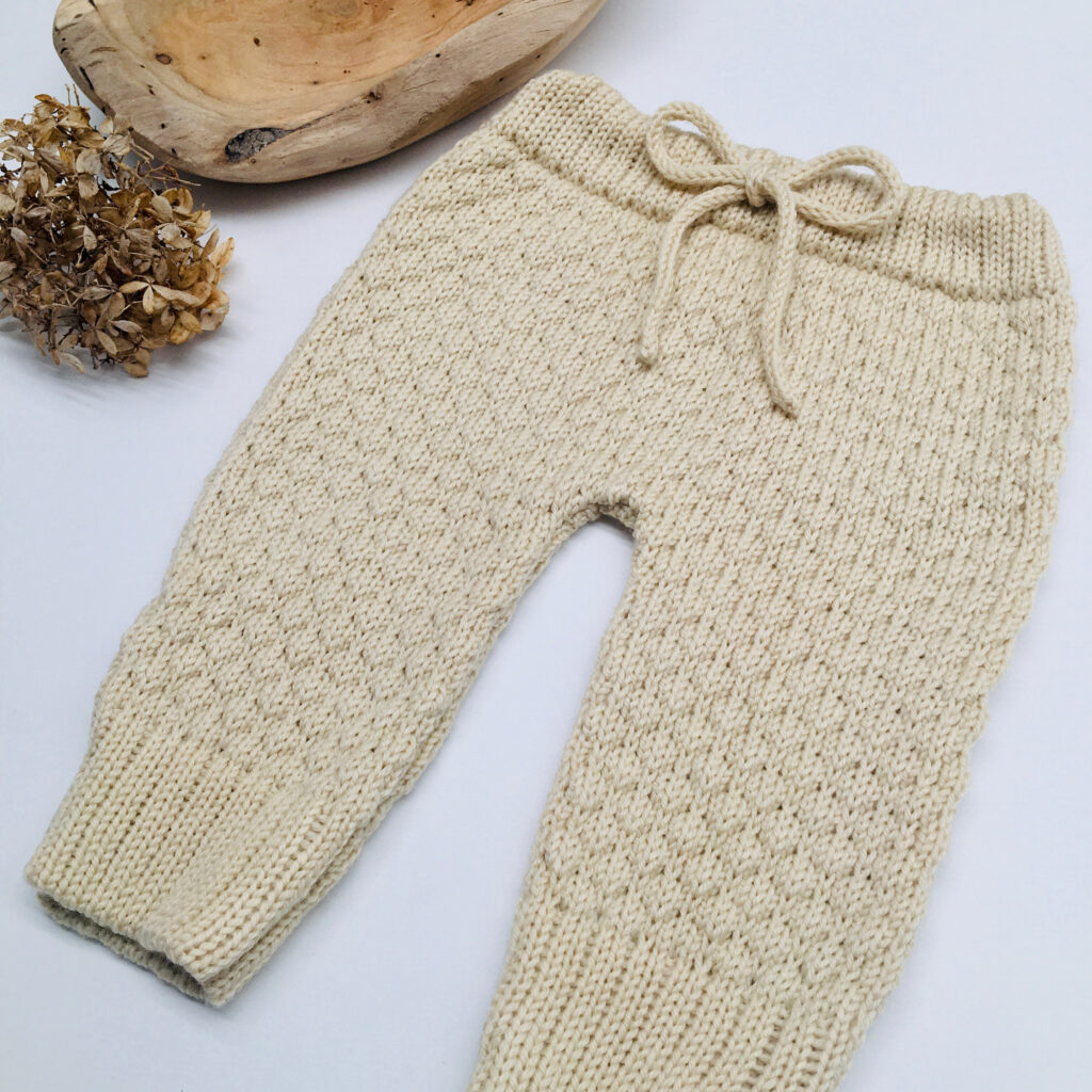 Handgefertigte Babyhose aus Merinowolle in Strickmuster